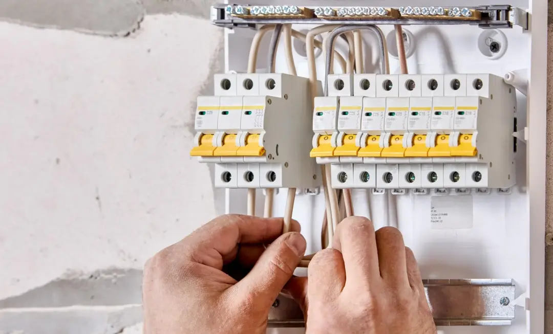 Electrician inspecting consumer unit warning signs